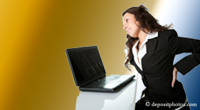a person Murfreesboro bending over a computer holding her back due to pain